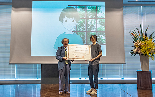 感謝際イベント2「はじめアルゴリズム」<br />
特別合格証授与式 記念撮影の様子<br />
(写真左から公益財団法人日本数学検定協会 会長 甘利俊一、<br />
「はじめアルゴリズム」作者 三原和人氏)